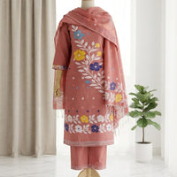 A three-piece women's salwar suit set in dusty rose pink. The set includes a kurta with colorful floral embroidery, matching trousers, and a coordinating dupatta.