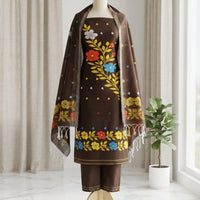 A brown traditional outfit  featuring a kurta with colorful floral embroidery, matching pants, and a matching shawl draped over the shoulders. 