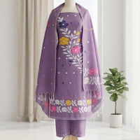 A purple traditional outfit , featuring a kurta with colorful floral embroidery, matching pants, and a draped shawl. 